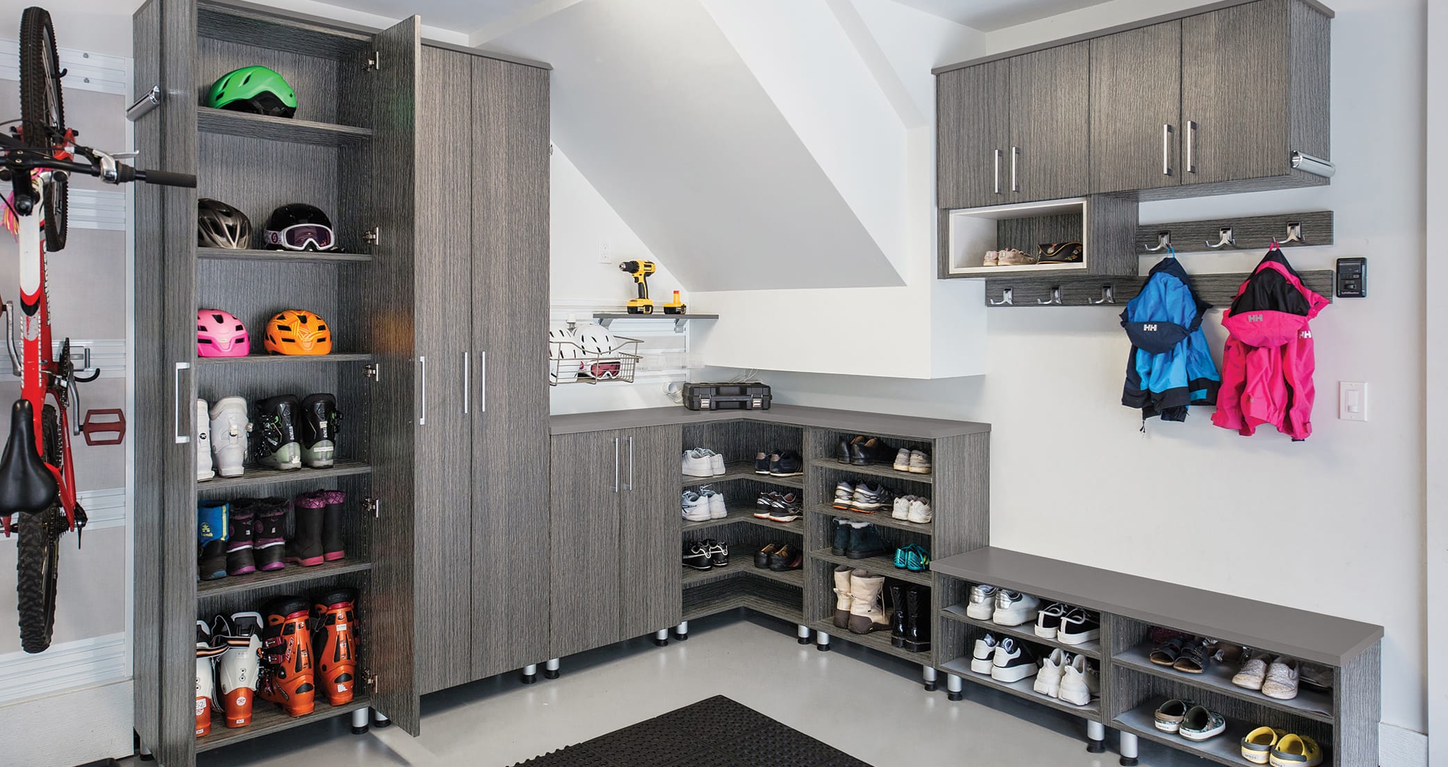 Custom solution for the garage complete with shoe and boot storage by California Closets