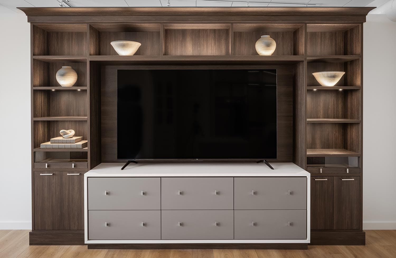 Customized white storage drawers for custom entertainment center dark wood finish by California Closets