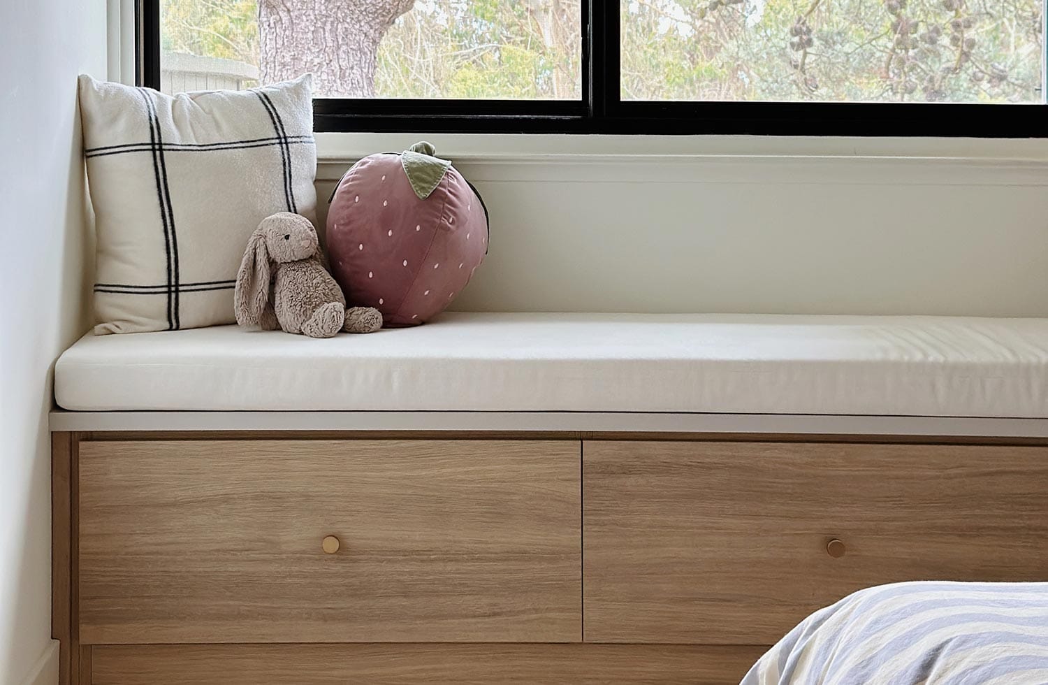 Bench seat with storage in light wood finish under the window from California Closets